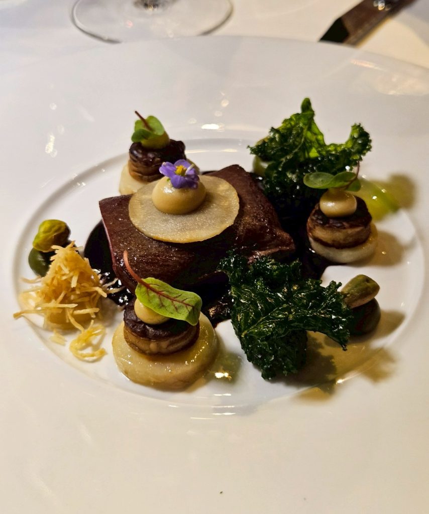 Venison with mole sauce and pistachio garnish