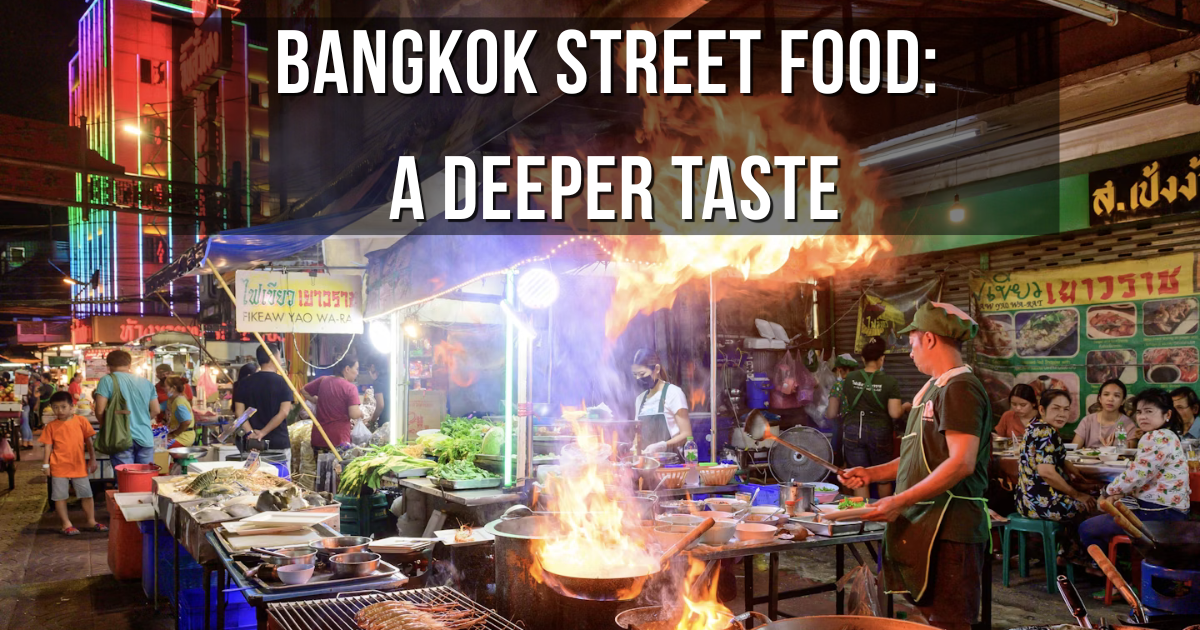 Street food vendor frying dishes with flames at a Bangkok night market