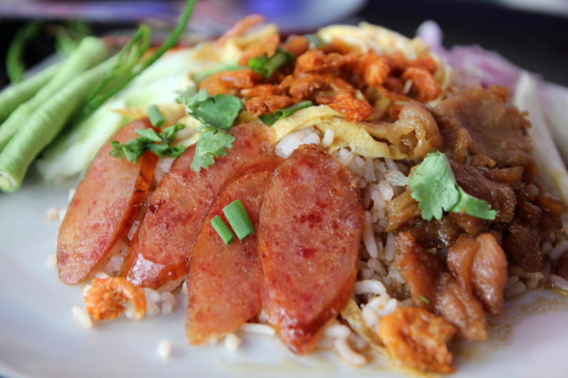 Plate of Khao Kluk Kapi with shrimp paste, sweet pork, and fresh mango