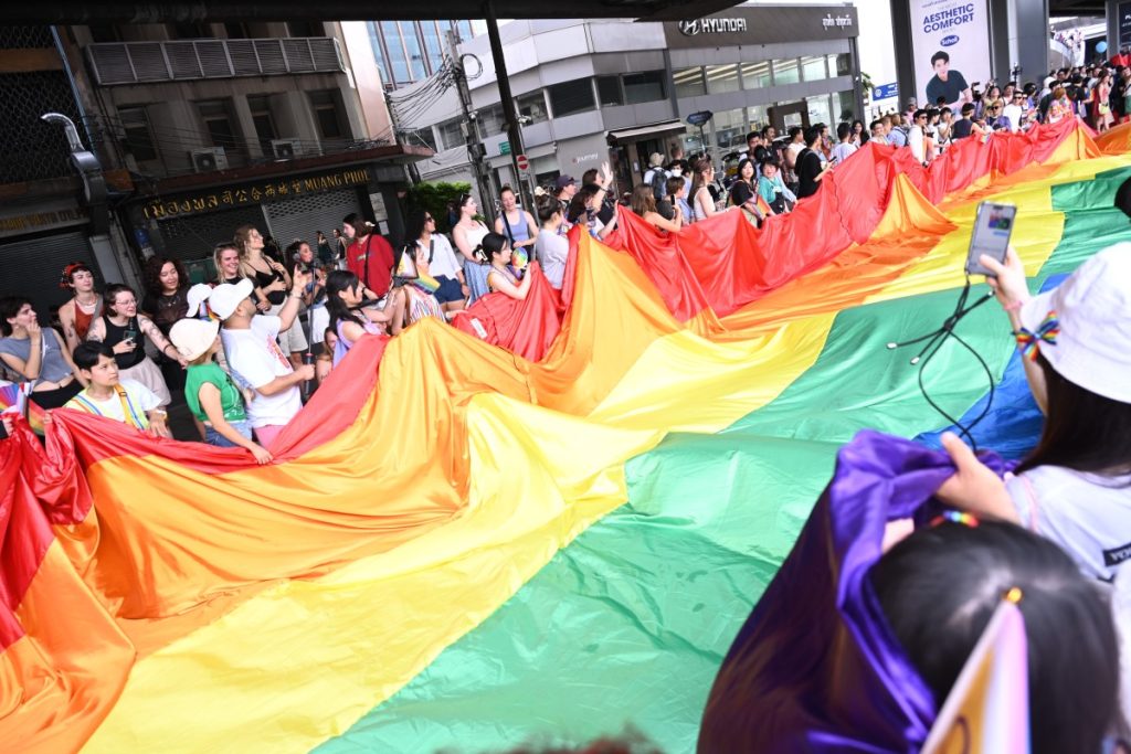 Participants holding a massive rainbow flag during Bangkok Pride 2025 parade.


