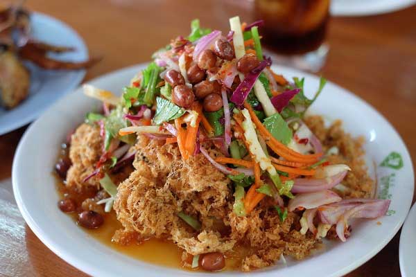 Crispy fried catfish flakes salad with shredded green mango and peanuts