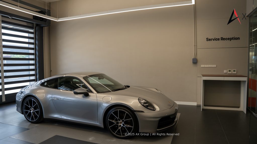 "Customer and Porsche technician in air-conditioned service bay at Porsche Centre Pattaya during pre-service vehicle inspection."