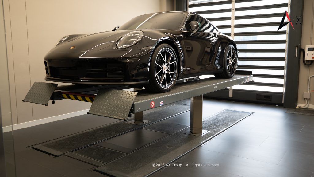 "Customer and Porsche technician in air-conditioned service bay at Porsche Centre Pattaya during pre-service vehicle inspection."