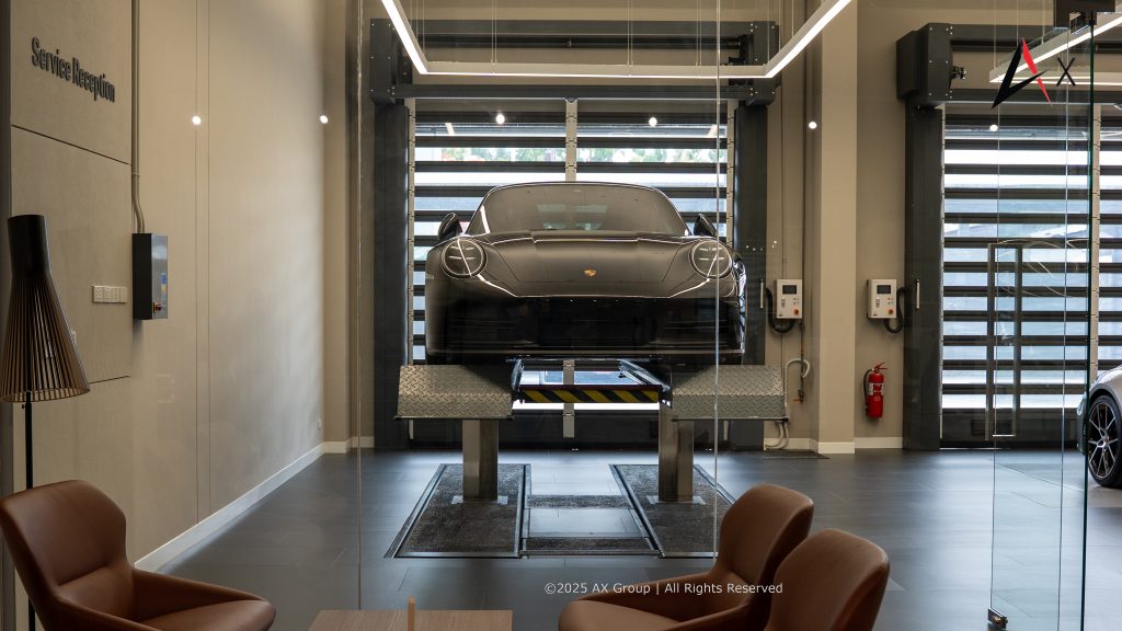 "Customer and Porsche technician in air-conditioned service bay at Porsche Centre Pattaya during pre-service vehicle inspection."